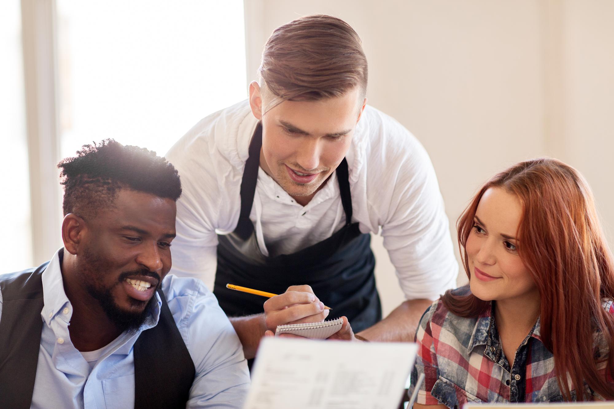 Consultant discussing menu with chef over table